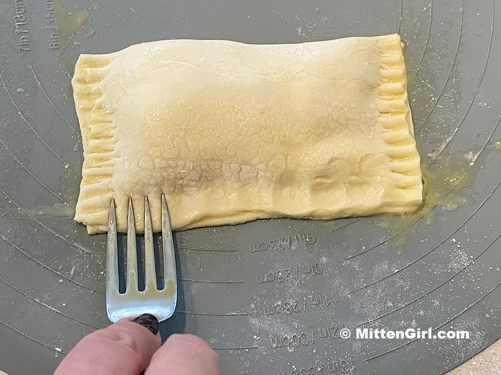 Crimp the edges of the pastry with a fork